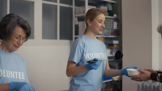 Young and elderly women volunteering at food center, helping feed the hungry - Powered by Adobe