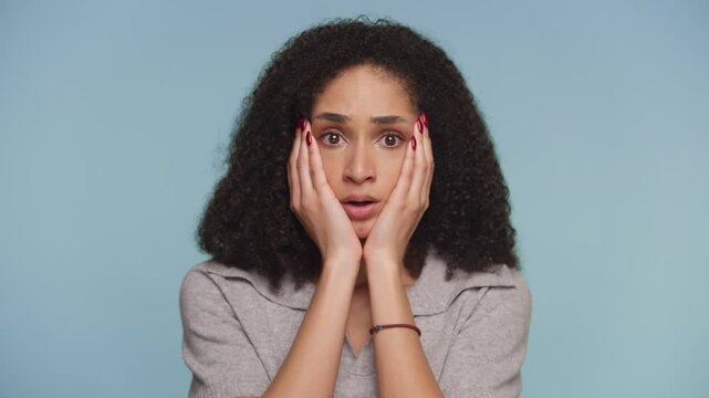 Shocked Woman Reacting to Unexpected News on Blue Background