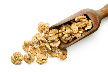 Top view of shelled walnuts on wooden scoop on white background.