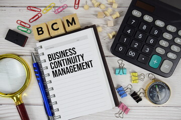 BCM - Business Continuity Management acronym on notepad, business and financial concept background
