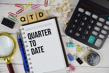 QTD Quarter To Date acronym on notepad, business and financial concept background