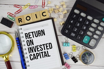 ROIC - Return on Invested Capital acronym on notepad, Business and Financial concept background