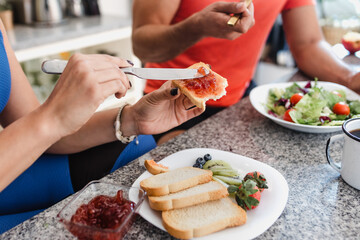 hands of fitness couple man and woman having a breakfast and drinking fruit juice and eating healthy food in kitchen at home in Mexico Latin America, hispanic young people in wellness concept