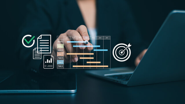 Project management tool and work schedule concept, Planning software, Businessman use laptop to manager working projects and update task with gantt chart schedule to business plan and progress.