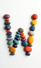 A creative and colorful number or letter designed with smooth, glossy stones in vibrant hues. The artistic typography combines polished pebbles and bright, candy-like elements