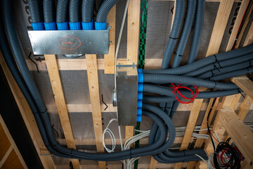 Interior view of house under construction featuring wooden beams, flexible ducts, metallic...