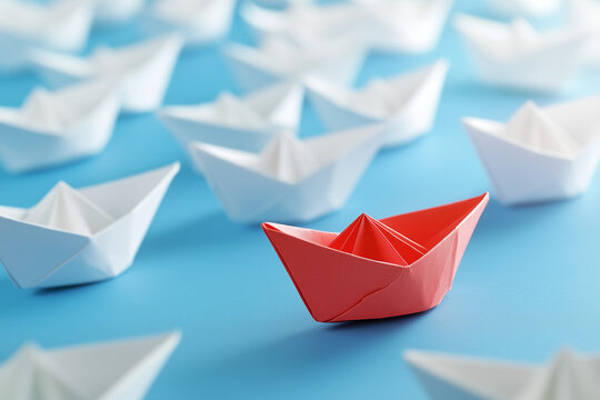 One being different from others. Red paper boat stands out crowd. Uniqueness and company business concept background.