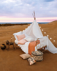 Romantic bed set up in the desert, by the sea, atmospheric weather conditions © Elnur