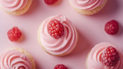 Delicious pink cupcakes topped with fresh raspberries on pink background