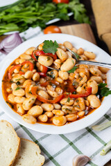 Lobio is a dish of Georgian, Azerbaijani and Armenian cuisines made from green bean pods. Lobio on a spoon. Traditional Georgian cuisine lobio. Lean dish. Lobio with pepper, onion. Side view.