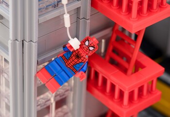 Naklejka premium Tambov, Russian Federation - January 06, 2025 A Lego Spiderman minifigure hanging from the web off the side of The Daily Bugle