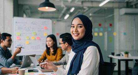 Team members actively discuss ideas and strategies while the woman in hijab engages with enthusiasm