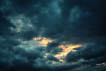 Fototapeta premium Dark stormy clouds with hints of light breaking through creating a dramatic sky