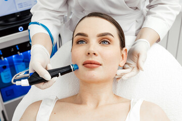 Close-up of a woman undergoing a hydropeeling facial treatment in a cosmetology clinic. Concept of...