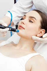 A woman receiving a hydrafacial treatment in a beauty salon. Concept of effective hydration and...