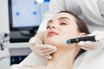 Close-up of a woman undergoing a hydropeeling facial treatment in a cosmetology clinic. Concept of...