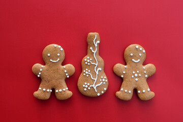 Romantic decorated gingerbread cookies in a shape of guitar and man, red background. Musical theme
