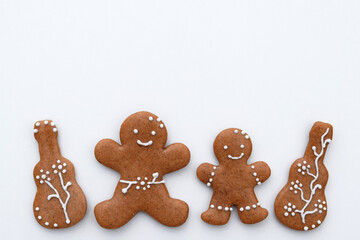 Romantic decorated gingerbread cookies in a shape of guitar and man, white background, copy space for text. Musical theme