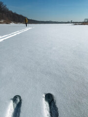 A person skis down a snowy road, immersed in the beautiful winter scenery and experiencing the...