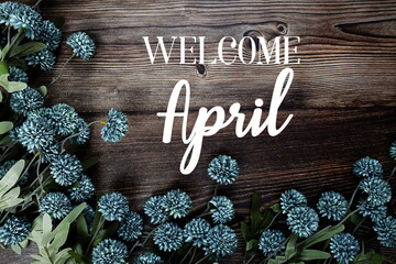 Welcome April text with flowers bouquet decoration on wooden background