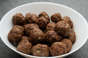 , Deutschland, Rheinland-Pfalz, 13.03.2025,  Knusprig gebratene Hackfleischbällchen mit Kräutern und Zwiebeln in einer weißen Schale. Perfekt für Fleischgerichte, Meal Prep und Food-Fotografie.