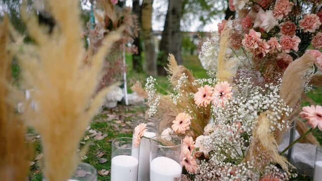 wedding arch of white and brown roses outdoors in the countryside in the forest in nature. Bride and groom wedding ceremony, festive romantic decor in boho style in autumn. Romance and love