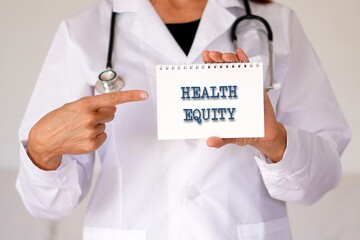 HEALTH EQUITY. words written in the notebook of a woman doctor.