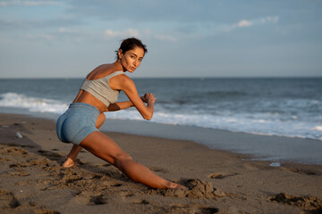 Focused Woman Stretching on the Beach During Workout