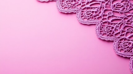 A delicate lavender lace edge lays on a smooth pink surface
