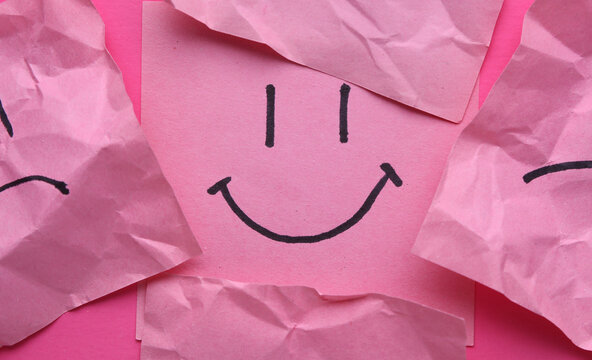 Naklejki Happy and Unhappy faces on crumpled square memo papers, pink background. Business concept