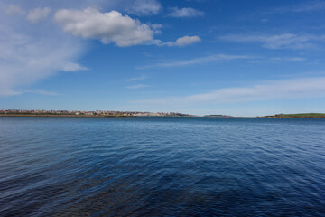 Bahía con el mar y el cielo azul, y la ciudad de Santander en el horizonte.