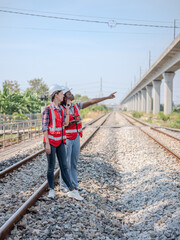 A female railway engineer points hand out the problematic areas for her colleagues to see and uses a radio to talk to maintenance personnel at the construction site.