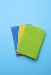 Kitchen abrasive sponges rags on blue background