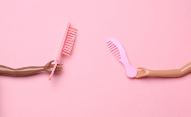 Dolls hans holding combs on pink background. Fashion concept. Fresh idea