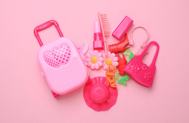 Women doll travel accessories on pink background. Flat lay