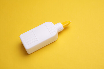 Bottle of PVA glue on a yellow background
