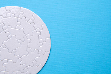White blank round Jigsaw puzzle on blue background. Mockup for design