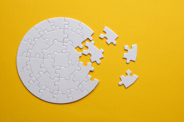 White blank round Jigsaw puzzle pieces disassembled.on yellow background. Mockup for design