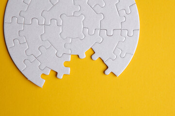 White blank round Jigsaw puzzle pieces disassembled.on yellow background. Mockup for design