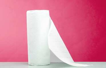 Roll of white paper towels on the table, pink background