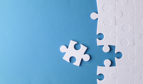 White jigsaw puzzle pieces on blue background.