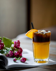 A cold cocktail with flowers on top of a book