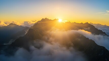 Breathtaking Sunrise Over Mountain Peaks with Clouds Below