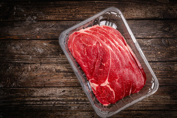 Raw fresh organic steak for cooking on a wooden background. Top view with copy space. High quality photo