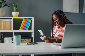 Young woman purchasing online with credit card and smartphone