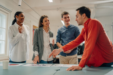 Marketing team analyzing charts and statistics during meeting in office
