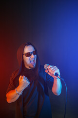 Rock singer man sings with microphone and sunglasses