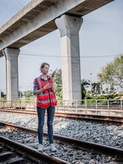 Engineer is on the railway, looking happy at work while inspecting the construction, train switch and inspecting the work at the train station. Concept: Determined to move forward, successful.