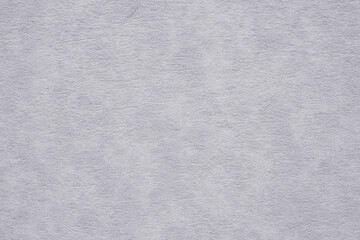 Macro detail texture of a grayish white paper with a marbled effect in soft light, perfect for backgrounds and graphic design.