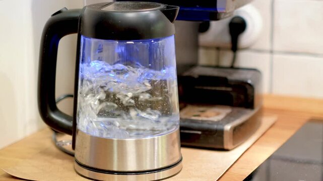 Water boils in a transparent electric kettle.